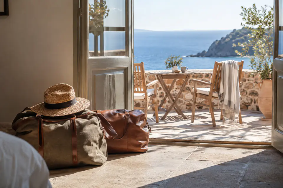 Bagages devant une terrasse méditerranéenne — illustration générée par IA
